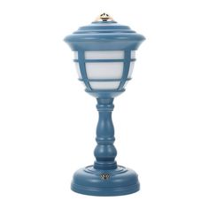 a blue lamp with a white light on top and a small gold object in the middle