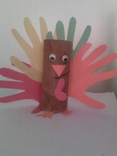 a paper bag with a turkey made out of handprints on top of it