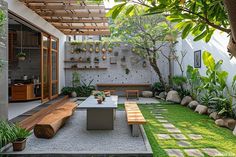 an outdoor dining area with wooden benches and plants on the wall, surrounded by grass