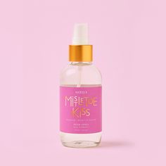 a bottle of miste kiss on a pink background