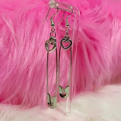 Take a fashionable risk with our Safety Pin Heart Earrings! These edgy earrings feature a heart charm attached to a safety pin, adding a cute and alternative touch to any outfit. Dare to be different and rock these unique earrings! Description: Item Type: EarringsEarring Type: Drop EarringsMetal Type: Iron AlloyOrigin: CNShape\Pattern: HeartMaterial: Metal Emo Style Metal Earrings For Gift, Emo Metal Earrings For Gift, Trendy Safety Pin Earrings For Pierced Ears, Trendy Everyday Heart Dangle Earrings, Trendy Pins As A Gift, Trendy Pins For Gifts, Trendy Single Safety Pin Earring, Trendy Safety Pin Single Earring, Trendy Paperclip-shaped Earrings As Gift