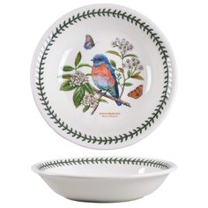 a white bowl with a blue bird on it next to a green and white plate