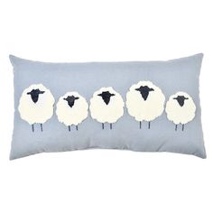 a blue pillow with sheep on it and four black ones in the same color scheme