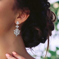 a close up of a woman's face wearing earrings with flowers on them,