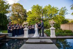 a bride and groom standing in front of their wedding party