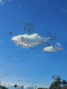 two kites flying in the sky above a street