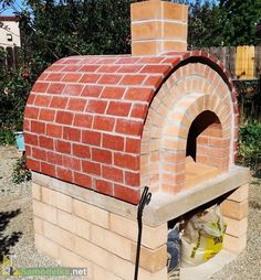 a brick oven sitting on top of a gravel field