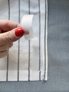 a person holding a roll of toilet paper on top of a piece of white fabric