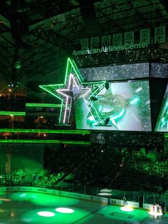 an ice hockey arena with green lights and stars on the wall