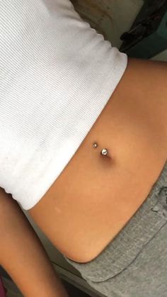 a woman's stomach with a piercing on it