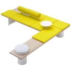 a yellow and white couch sitting on top of a wooden table