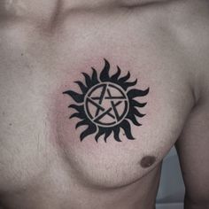 a man's chest with a pentagramil tattoo on it and the sun