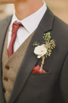 a man in a suit and tie with a boutonniere on his lapel