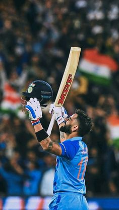 a man holding a cricket bat in his right hand and looking up at the sky