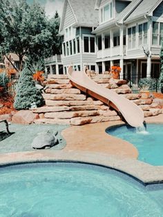 a pool with a slide in it next to a house