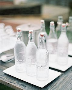 several empty water bottles sitting on top of a wooden table