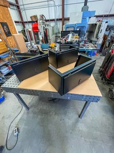 two metal boxes sitting on top of a table in a room filled with other items