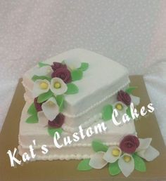 two tiered cake decorated with flowers and leaves