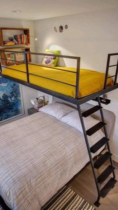 a bunk bed with a ladder to the bottom and a yellow bedspread on top