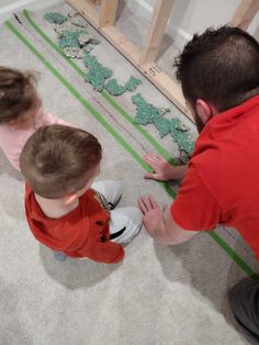 two small children are playing on the floor with their hands in front of each other