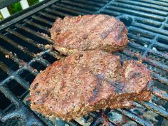 two hamburger patties are cooking on the grill