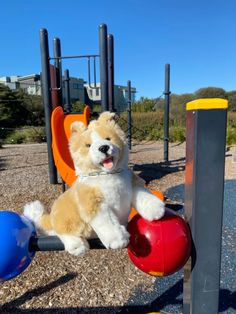 a teddy bear sitting on top of a playground