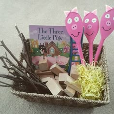 three little pigs are sitting in a basket with books and sticks to make them look like they're happy