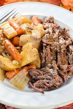 a white plate topped with meat, potatoes and carrots