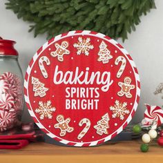 a red and white sign that says baking spirits bright next to some candy canes