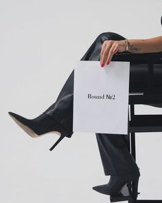 a woman sitting in a chair holding a sign