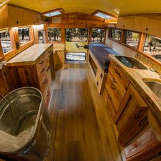 an interior view of a bus with wood flooring and cabinets in the foreground