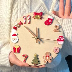 a person holding a clock with christmas decorations on it