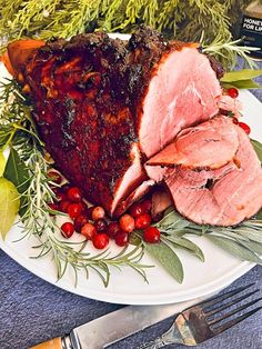 a white plate topped with meat covered in cranberry sauce and garnish