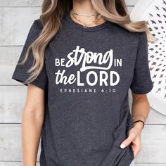 This Gender-Neutral Adult T-shirts item is sold by BrookeFaithCo. Ships from Hialeah, FL. Listed on Jan 15, 2024 Inspirational Crew Neck T-shirt With Lettering, Inspirational Lettering Crew Neck T-shirt, Crew Neck Top With Lettering, Be Strong In The Lord, Strong In The Lord, Ephesians 6 10, Bible Verse Shirt, Christian T Shirt, Christian Apparel