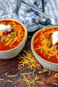 two bowls of chili with cheese and sour cream