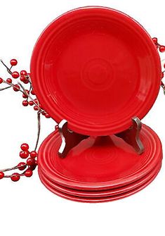 three red plates with berries on them are stacked next to each other in front of a white background