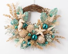 a wreath decorated with sea shells and green ornaments