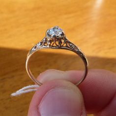 someone is holding an old diamond ring in their hand