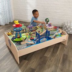 a little boy playing with his toy train set