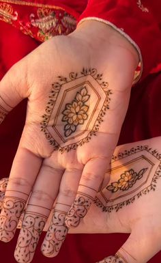 a woman's hands with henna tattoos on them, both holding their hands together