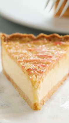 a piece of cheesecake sitting on top of a white plate with a fork in it