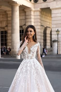 a woman in a wedding dress standing on the street