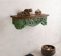 a green shelf with some animals on it and a bowl of nuts in the foreground