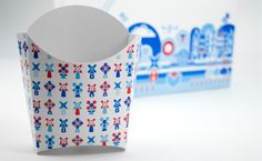 a paper cup with red, white and blue designs on it next to a box