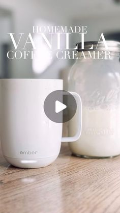 a mason jar sitting on top of a wooden table next to a glass cup filled with milk