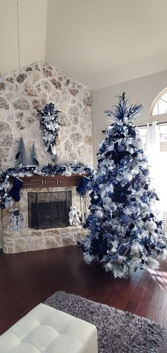 a living room decorated for christmas with blue and silver decorations on the fireplace mantel