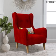 a red chair sitting next to a white vase with a plant in it and a clock on the wall