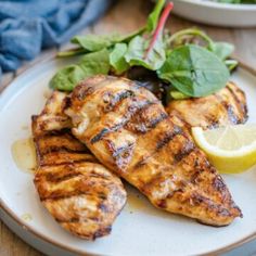 grilled chicken with greens and lemon on a plate