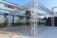 an outdoor stage set up in front of a building with ropes and poles attached to it