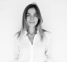 a black and white photo of a woman with long hair, wearing a button up shirt